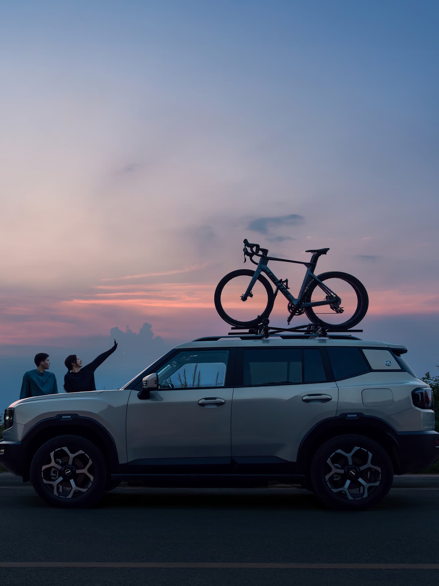 Jetour T1 IDM side profile with roof-mounted bicycle against a sunset sky